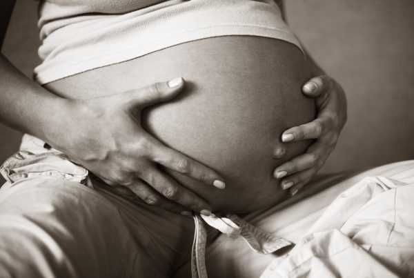 VBAC like a boss - image of pregnant belly with pregnant persons hands gently caressing it