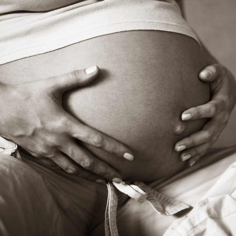 VBAC like a boss - image of pregnant belly with pregnant persons hands gently caressing it